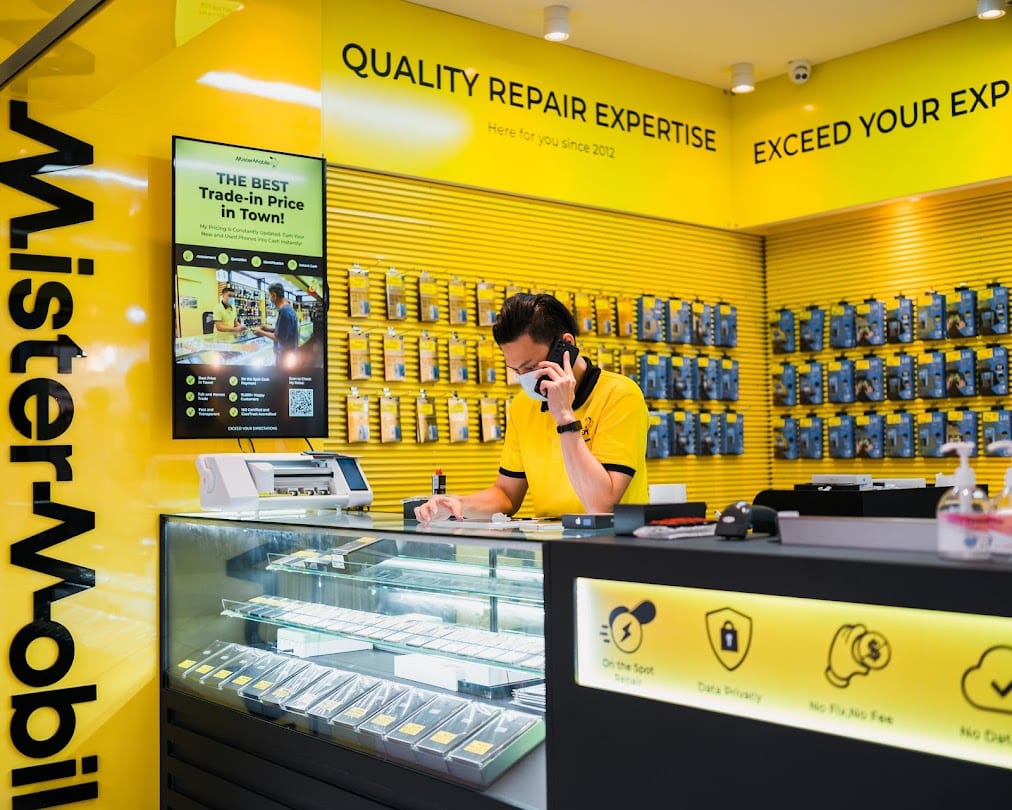 Mister Mobile repair counter with staff, trade-in pricing screen and accessory wall