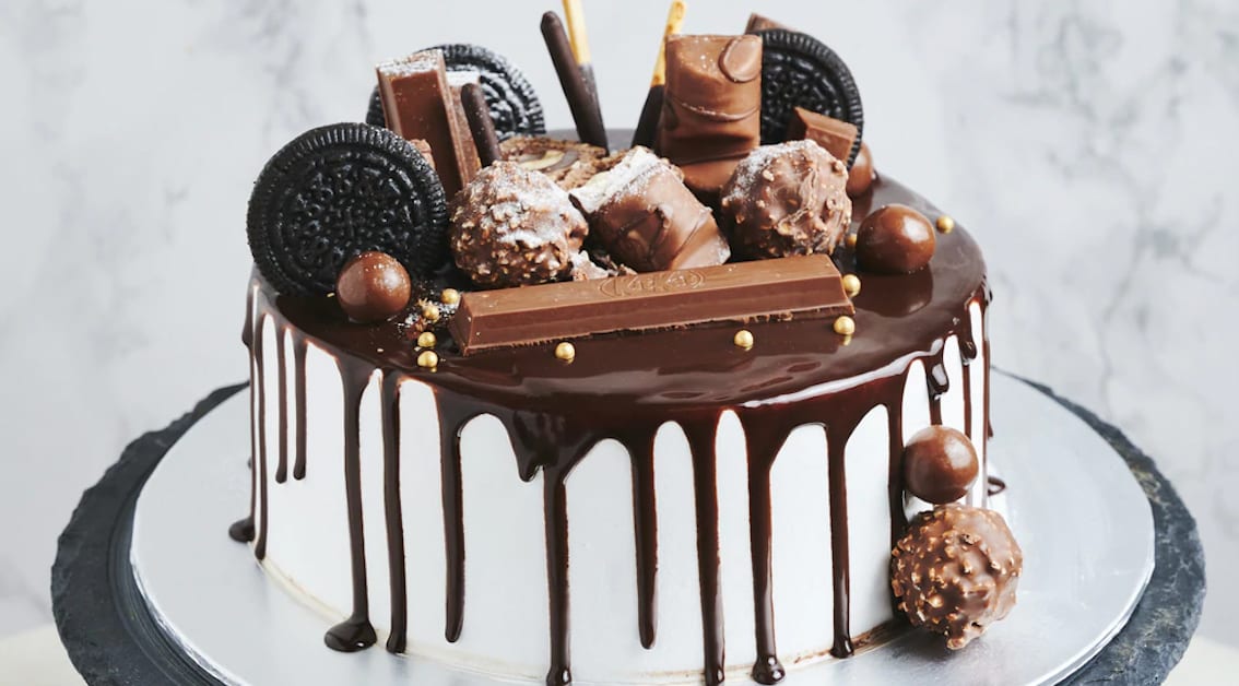 Temptations chocolate drip cake topped with chocolates and cookies