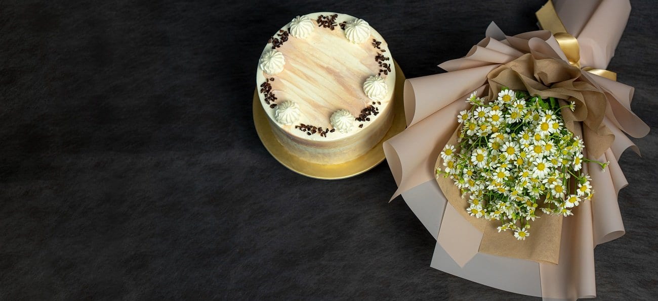 Dig In Cakes cake beside a daisy bouquet