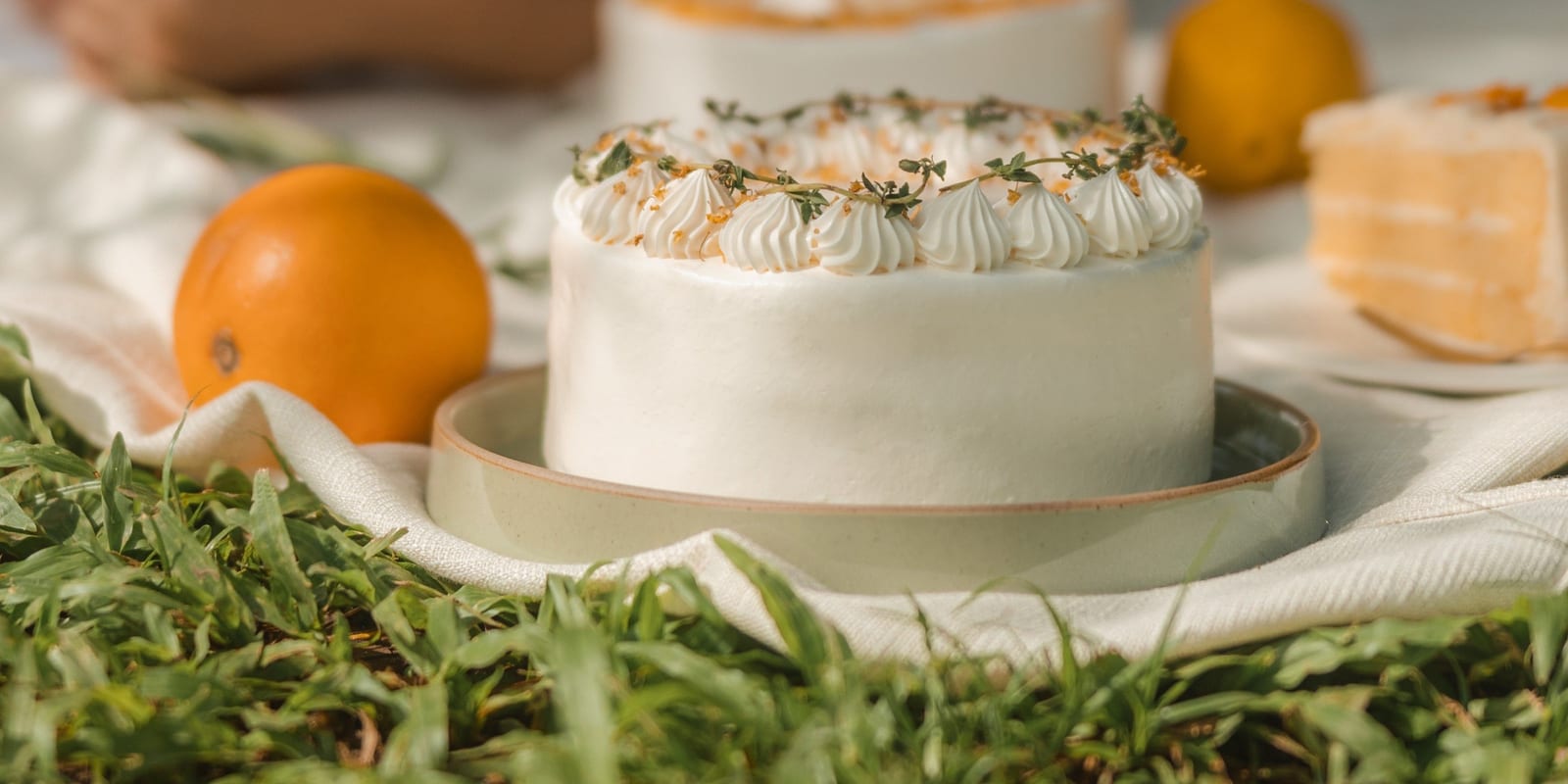 Fieldnotes cream cake with piped rosettes and herbs